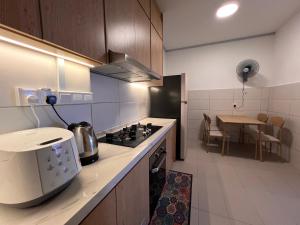 a kitchen with a stove and a microwave in it at Sireh Family Homestay in Kota Bharu