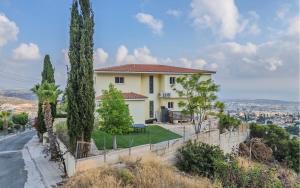 a house on a hill with trees and a road at Villa Horizon in Peyia