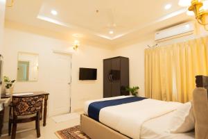 a bedroom with a bed and a desk and a television at Hotel Granton in Hyderabad