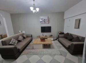 a living room with two couches and a coffee table at Sardar house in Rāwala Kot