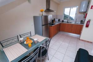 a kitchen with a table and a refrigerator at Cozy Private Apartment Calheta in Arco da Calheta +3 photos