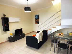 a living room with a table and a dining room at Cozy Private Apartment Calheta in Arco da Calheta