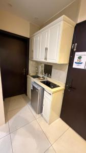 a small kitchen with white cabinets and a sink at نوليتا للشقق الفندقية in Abha