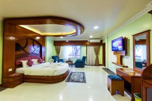 a hotel room with a large bed and a television at Hotel Earth Light, Chitwan National Park in Sauraha