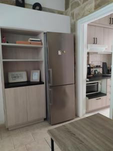 a kitchen with a stainless steel refrigerator and a table at Seaside pearl in Lygia