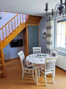 ein Esszimmer mit Tisch und Stühlen und einer Treppe in der Unterkunft Cichy Zaułek Górki Wielkie in Górki Wielkie