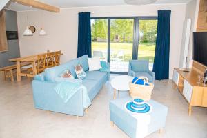 a living room with a blue couch and a table at Osada plażowa in Białogóra