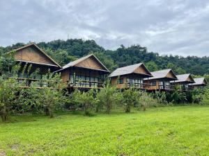 una fila de casas de madera en un campo en PhouPhet PhouKham Lodge, en Luang Namtha