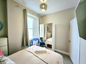 a bedroom with a bed and a chair and a window at Sensational Stay- Fountainbridge in Edinburgh