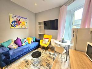 a living room with a blue couch and a table at Sensational Stay- Fountainbridge in Edinburgh