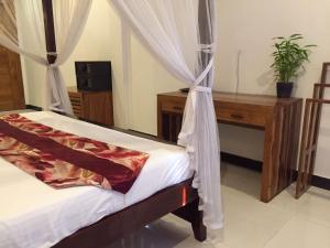 una camera con letto, scrivania e tende di Marine Hostel at Negombo Beach a Negombo