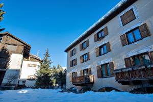 a building with snow on the ground in front of it at Chesa Centrum 6pax - Celerina in Celerina