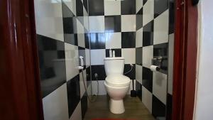 a bathroom with a toilet with black and white tiles at 2 Bedroom Ground Floor Apartment 1 km from the Beach in Belle Mare +5 photos