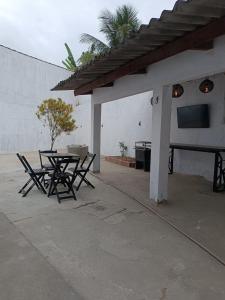 a patio with a table and chairs and a wall at UniqueFlats - Casa Mosaico in Nova Iguaçu