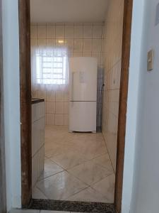 an empty kitchen with a refrigerator in a room at UniqueFlats - Casa Mosaico in Nova Iguaçu