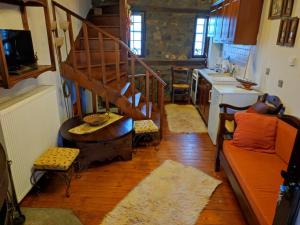 a living room with a spiral staircase and a kitchen at Villa Erotokritos in Palaios Agios Athanasios