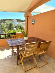 a wooden table and chairs on a patio at Casa Bonita Vista Porto in Santa Teresa Gallura