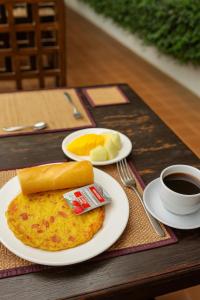 a breakfast of omelet and fruit and a cup of coffee at PP Guesthouse LPB in Luang Prabang