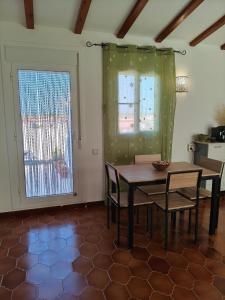 a dining room with a table and chairs and a window at L'àtic dels flamencs in Sant Jaume d'Enveja +12 photos