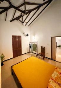 a bedroom with a yellow bed in a room at Casa Araliya in Negombo