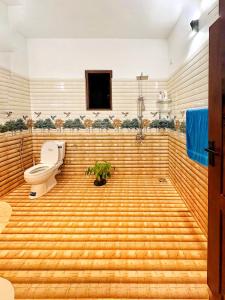 a bathroom with a wooden floor and a toilet at Casa Araliya in Negombo +11 photos