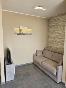 a living room with a couch and a flat screen tv at Casa Cleo in Tortoreto Lido