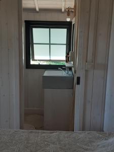 un bagno con lavandino e finestra di Moorea a Bassignac-le-Haut