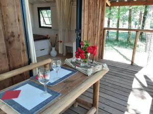 un tavolo in legno con due bicchieri da vino su un portico di Moorea a Bassignac-le-Haut
