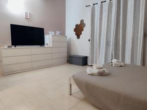a bedroom with a bed and a flat screen tv at Appartamento Sofia in zona residenziale strategica wifi gratuito in Carbonara al Ticino