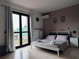a bedroom with a bed and a large window at Appartamento Sofia in zona residenziale strategica wifi gratuito in Carbonara al Ticino