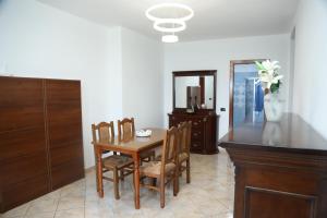 a dining room with a table and chairs and a mirror at Emerald House Shiroke in Shkodër