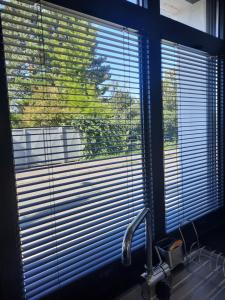 una finestra della cucina con tende sopra un lavandino di Le cottage , logement individuel de plain pied a Villeneuve d'Ascq