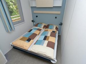 a bed in a room with a window at Mobile Home in Sachsenburg by River Drau in Sachsenburg
