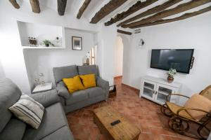 ein Wohnzimmer mit Sofa und Fernseher in der Unterkunft Casa Rural Zambra in Priego de Córdoba