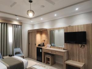 a hotel room with a bed and a desk with a mirror at اجنحة مأرز الايمان in Medina