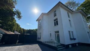 a white house with the sun in the sky at Royal Horses in Overijse