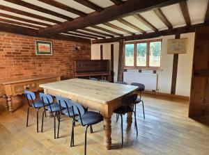 a dining room with a wooden table and chairs at The Farmhouse, Holly Tree Barns in Cratfield +8 photos