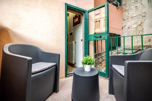 un patio con 2 sedie e un tavolo con una pianta in vaso di Modern Suite in Florence a Firenze