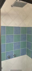 eine Dusche mit blauen und grünen Fliesen in einem Badezimmer in der Unterkunft Casa de 2 habitaciones, Santa Cruz Norte in Santa Cruz de la Sierra