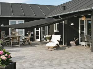 luifel boven een terras met stoelen en tafels op een huis bij 10 person holiday home in Nysted-By Traum in Nysted