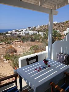 a table on a porch with a view of the ocean at Στούντιο Σκοπελίτης 2 in Donoussa