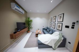 ジッダにあるLuxury two bedroom Apartment As Salamahの青いソファとテレビのあるリビングルーム