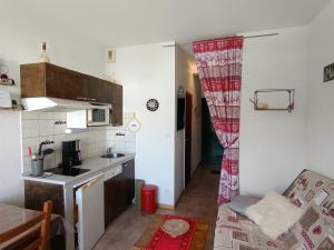 eine kleine Küche mit einem roten Vorhang in einem Zimmer in der Unterkunft Studio charmant 4 pers, vue montagnes, parking inclus - FR-1-445-206 in Montgenèvre