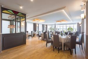 a dining room with a table and chairs and windows at Miramar Suites in Sada +33 photos