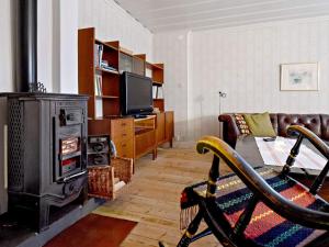 a living room with a wood stove and a couch at 8 person holiday home in Östmark in Östmark