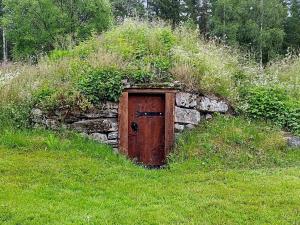 a stone wall with a door in the grass at Historic Charm in Varmland Oasis-By Traum in Östmark