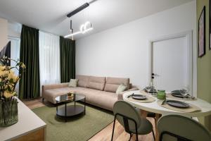 a living room with a couch and a table at Rossini King bed i BR Apartment in Bucharest