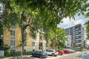 a row of cars parked on a street with buildings at Rossini King bed i BR Apartment in Bucharest