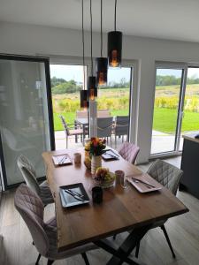 a dining room with a wooden table and chairs at VILLA VULKANEIFEL -modern -familienfreundlich -Terrasse -Doppelgarage -ruhiger Lage in Darscheid