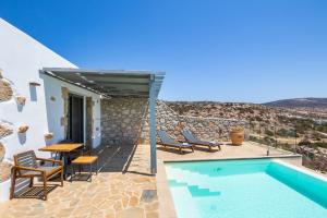a villa with a swimming pool and a table and chairs at SOPHID Wellness Suites Karpathos in Karpathos Town